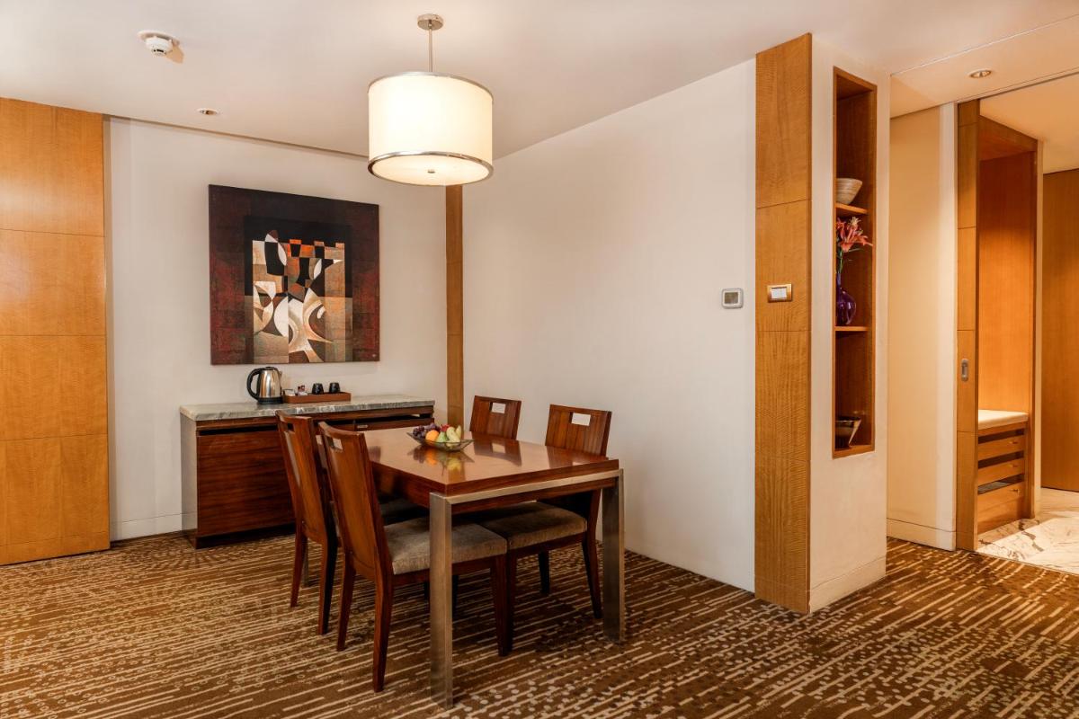 a kitchen and dining room with a table and chairs at Hyatt Regency Pune Hotel & Residences in Pune