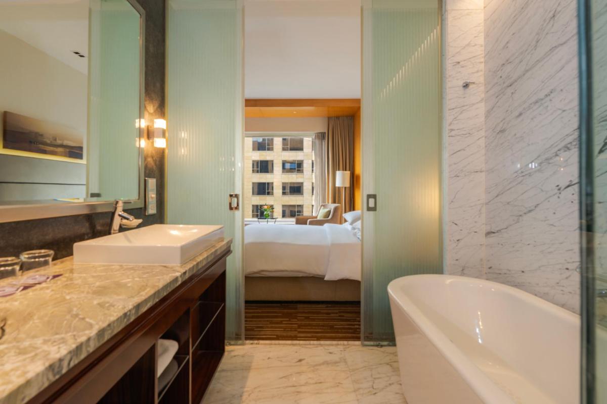 a bathroom with a tub and a bedroom with a bed at Hyatt Regency Pune Hotel & Residences in Pune