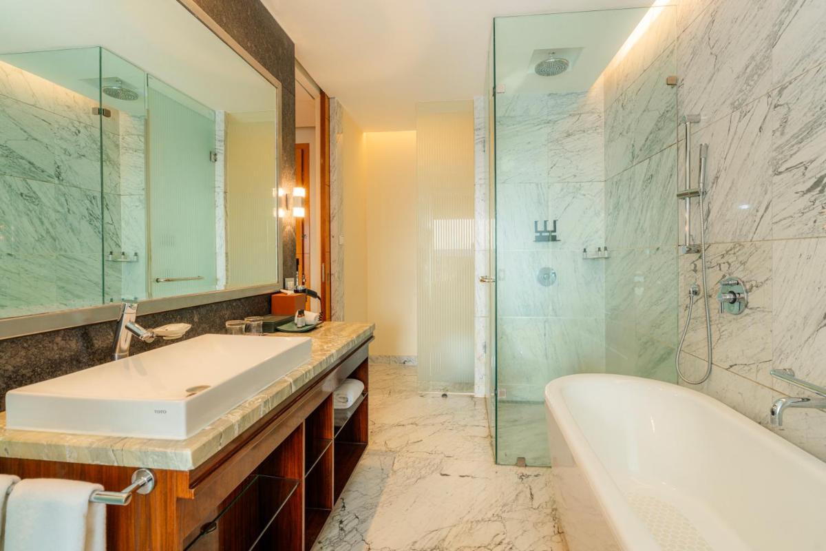 a bathroom with a tub and a sink and a shower at Hyatt Regency Pune Hotel & Residences in Pune
