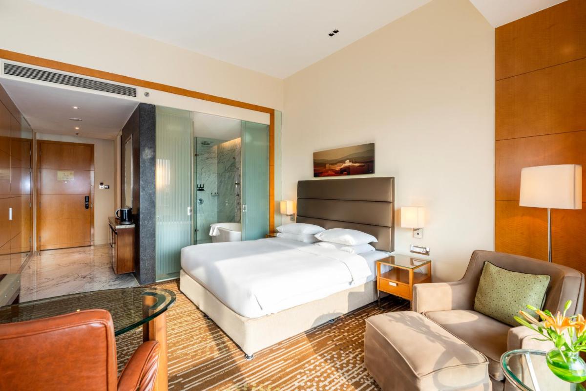 a hotel room with a bed and a living room at Hyatt Regency Pune Hotel & Residences in Pune