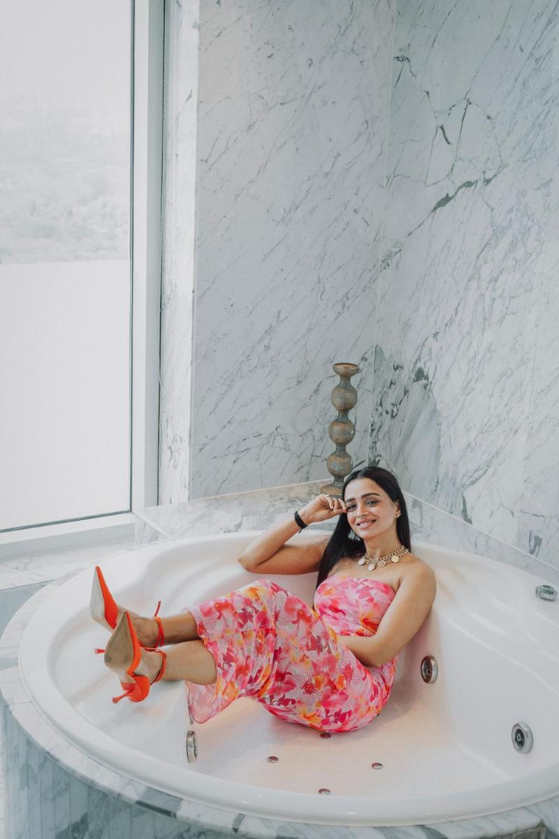 a woman is sitting in a bath tub at Hyatt Regency Pune Hotel & Residences in Pune