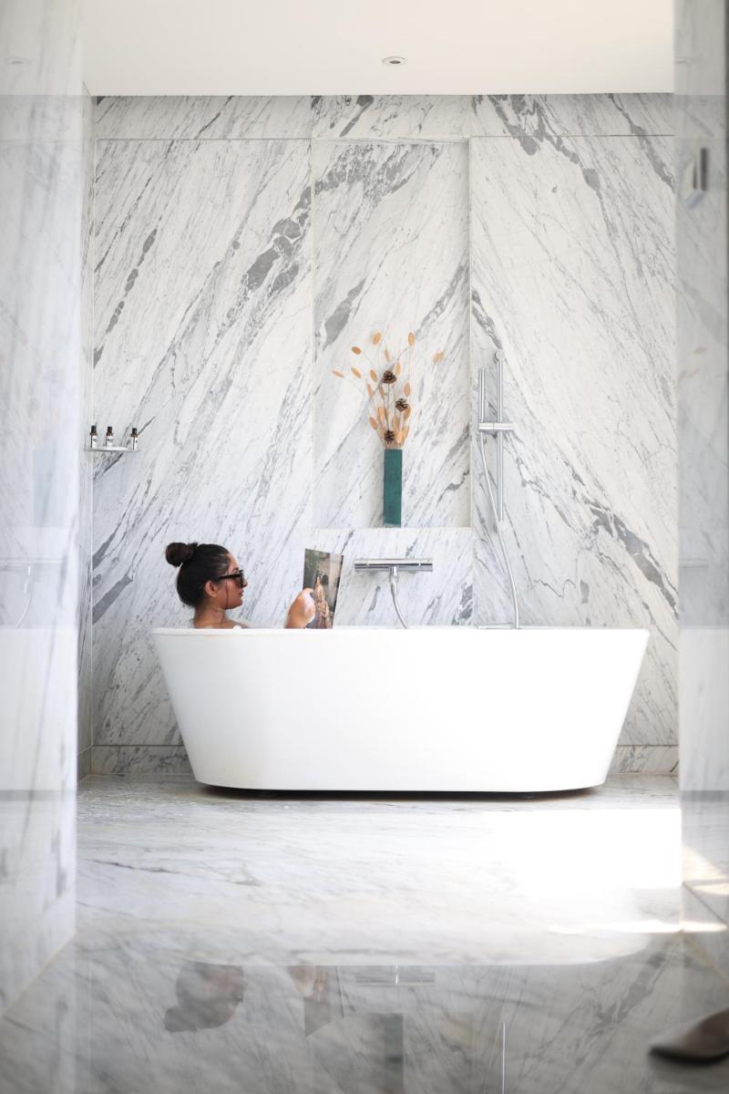 a woman sitting in a bath tub in a bathroom at Hyatt Regency Pune Hotel & Residences in Pune