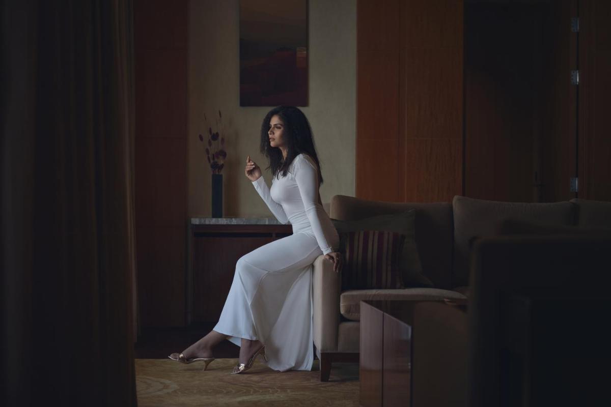a woman in a white dress sitting on a couch at Hyatt Regency Pune Hotel & Residences in Pune