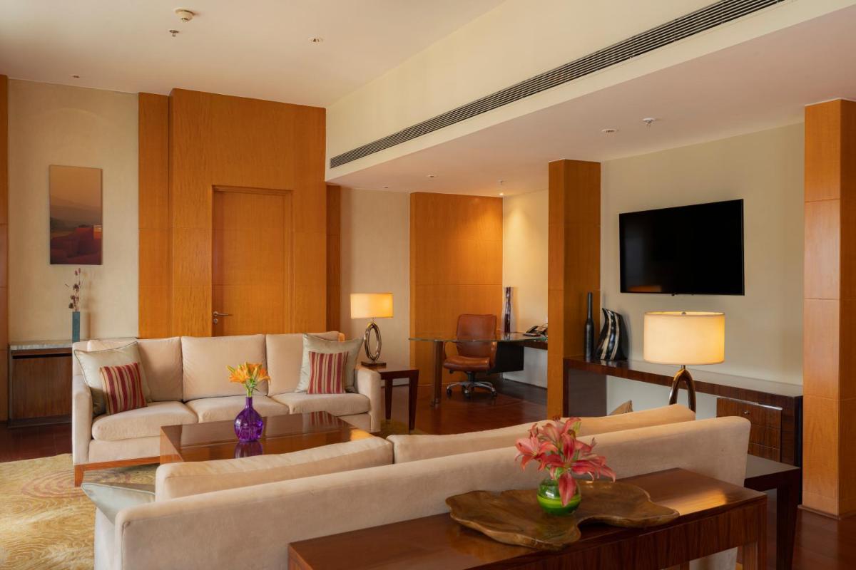 a living room with couches and a tv and a table at Hyatt Regency Pune Hotel & Residences in Pune