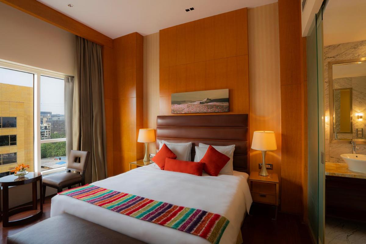 a hotel room with a bed and a bathroom at Hyatt Regency Pune Hotel & Residences in Pune