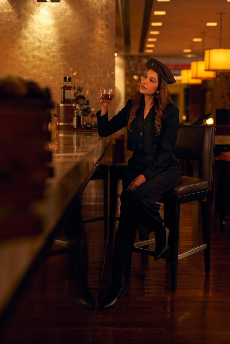 a woman sitting in a chair holding a glass of wine at Hyatt Regency Pune Hotel & Residences in Pune
