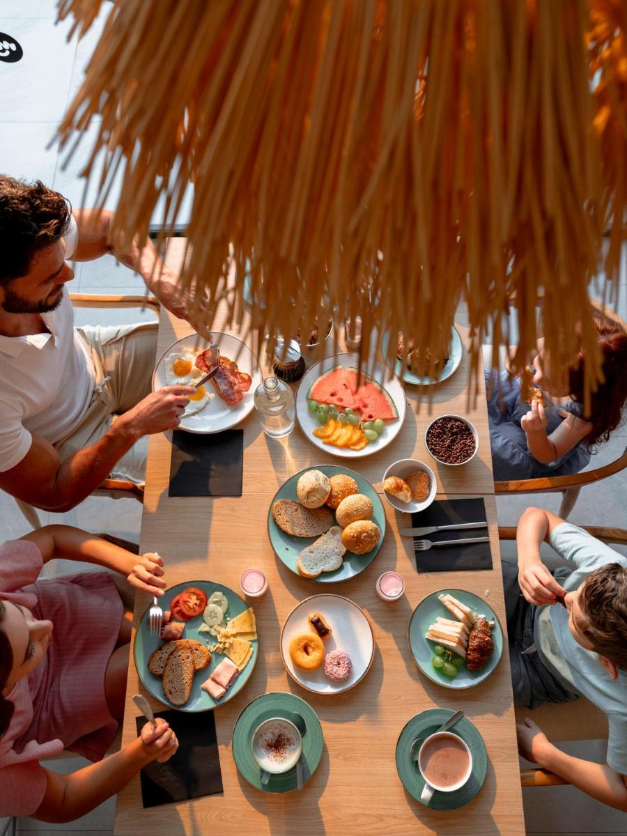 un grupo de personas sentadas alrededor de una mesa con comida en MYND Yaiza, en Playa Blanca