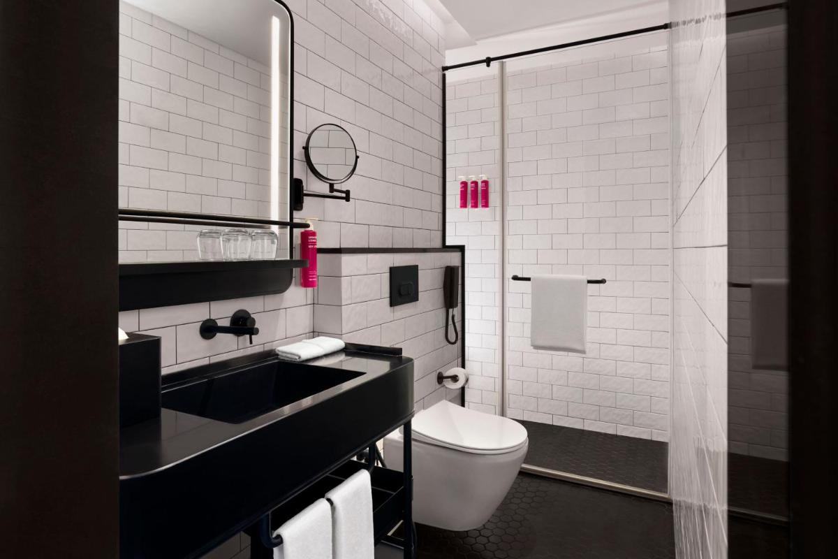 a white bathroom with a sink and a toilet at Moxy Mumbai Andheri West in Mumbai