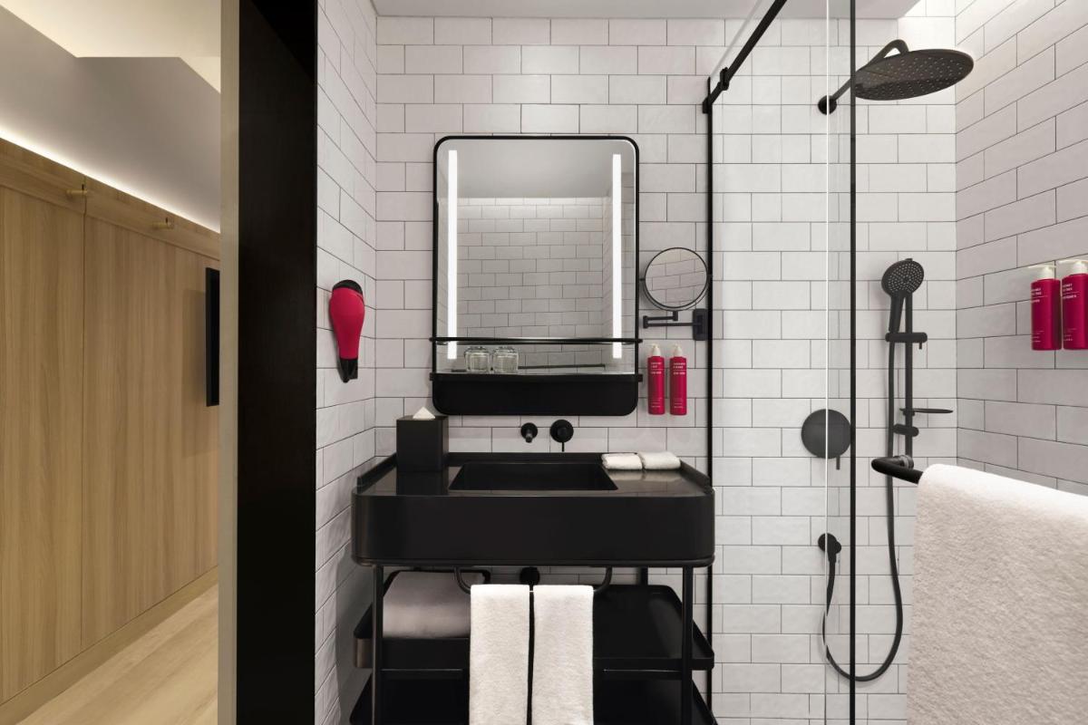 a bathroom with a black sink and a mirror at Moxy Mumbai Andheri West in Mumbai a bathroom with a black sink and a mirror at Moxy Mumbai Andheri West in Mumbai
