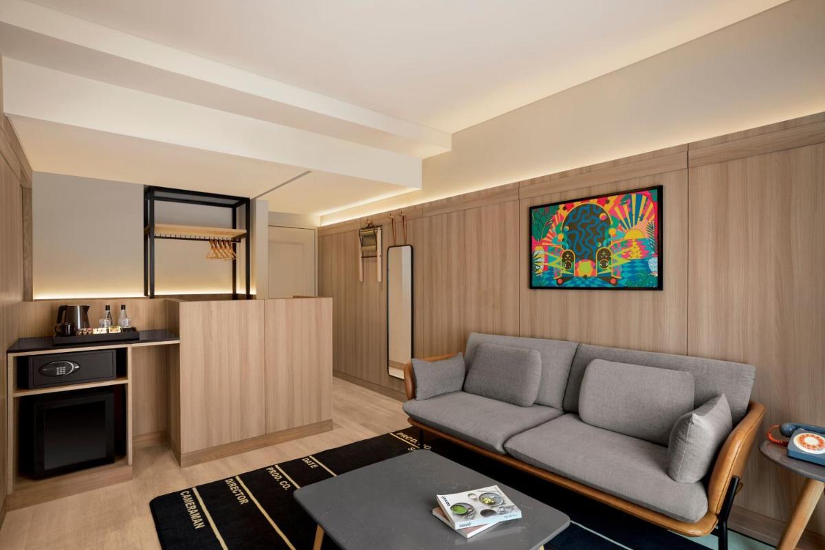 a living room with a couch and a kitchen at Moxy Mumbai Andheri West in Mumbai