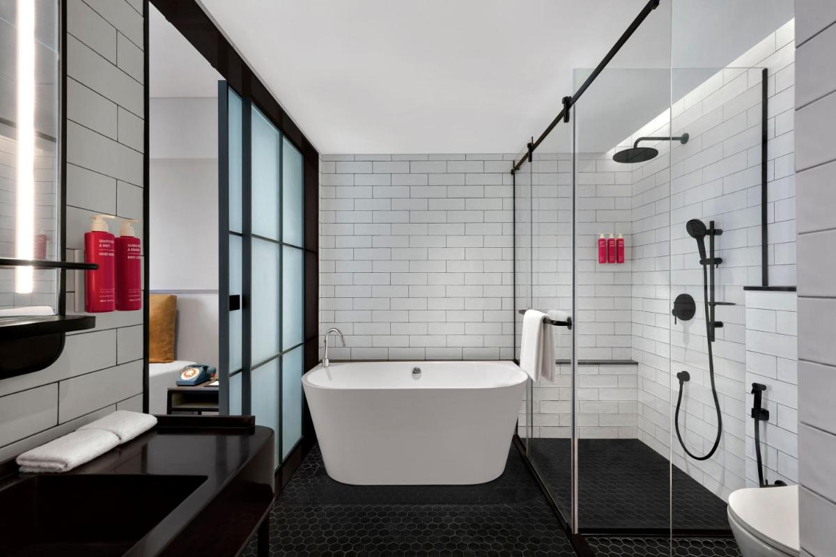 a bathroom with a bath tub and a shower at Moxy Mumbai Andheri West in Mumbai
