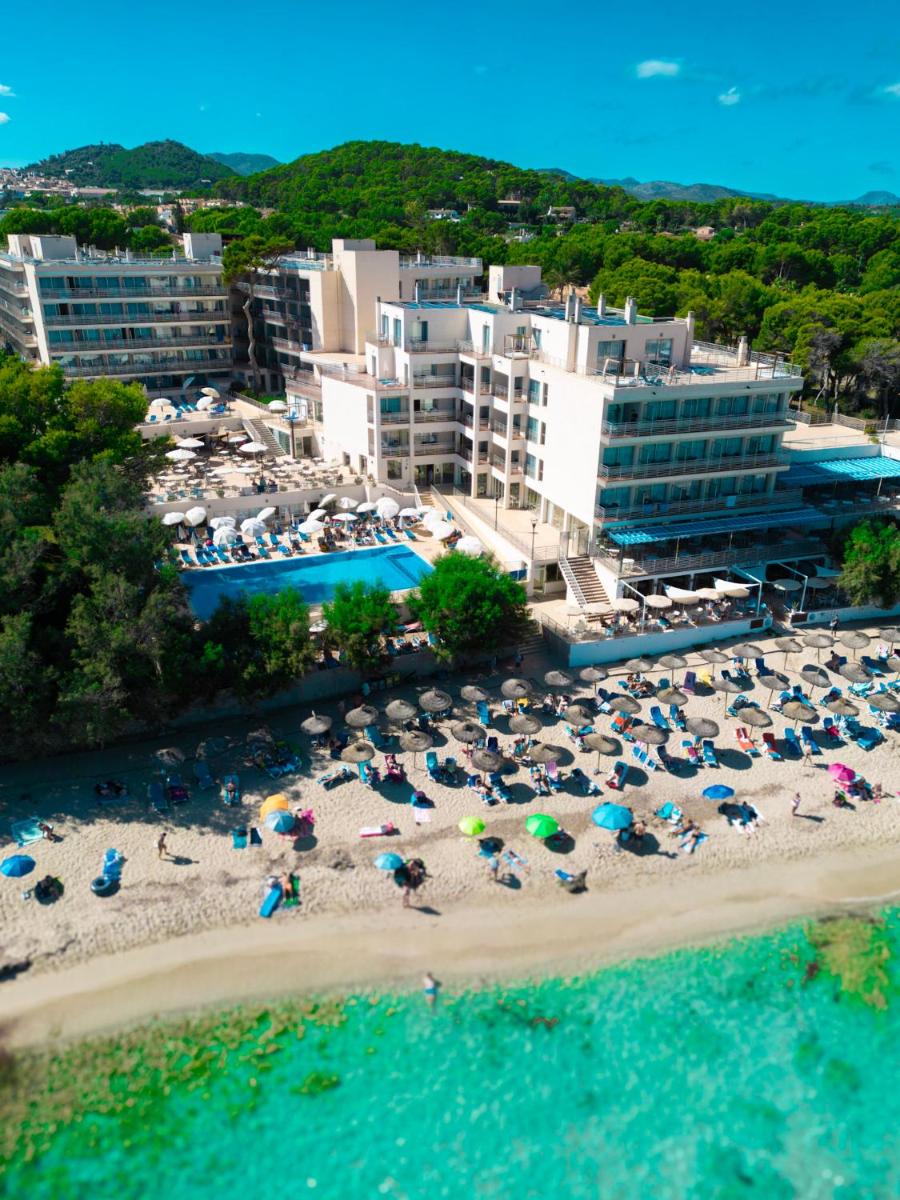 Una vista aérea de una playa con gente y sombrillas. en Hotel Na Forana, en Cala Ratjada
