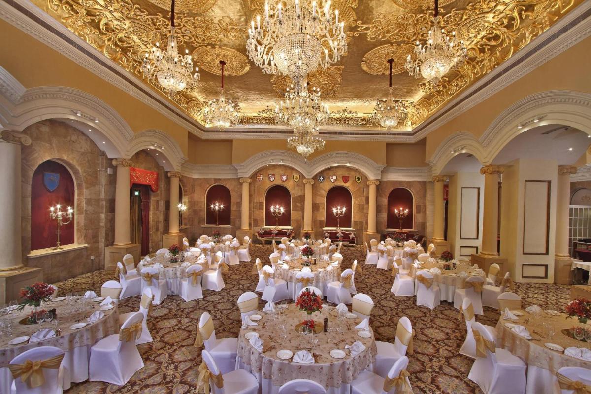 a banquet hall with white tables and chairs and chandeliers at ITC Windsor, a Luxury Collection Hotel, Bengaluru in Bengaluru a banquet hall with white tables and chairs and chandeliers at ITC Windsor, a Luxury Collection Hotel, Bengaluru in Bengaluru