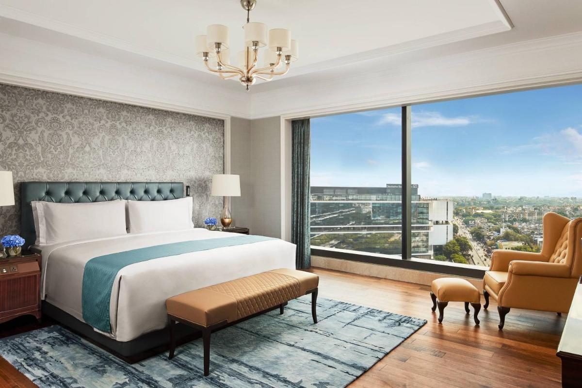 a bedroom with a bed and a large window at The Ritz-Carlton, Pune in Pune