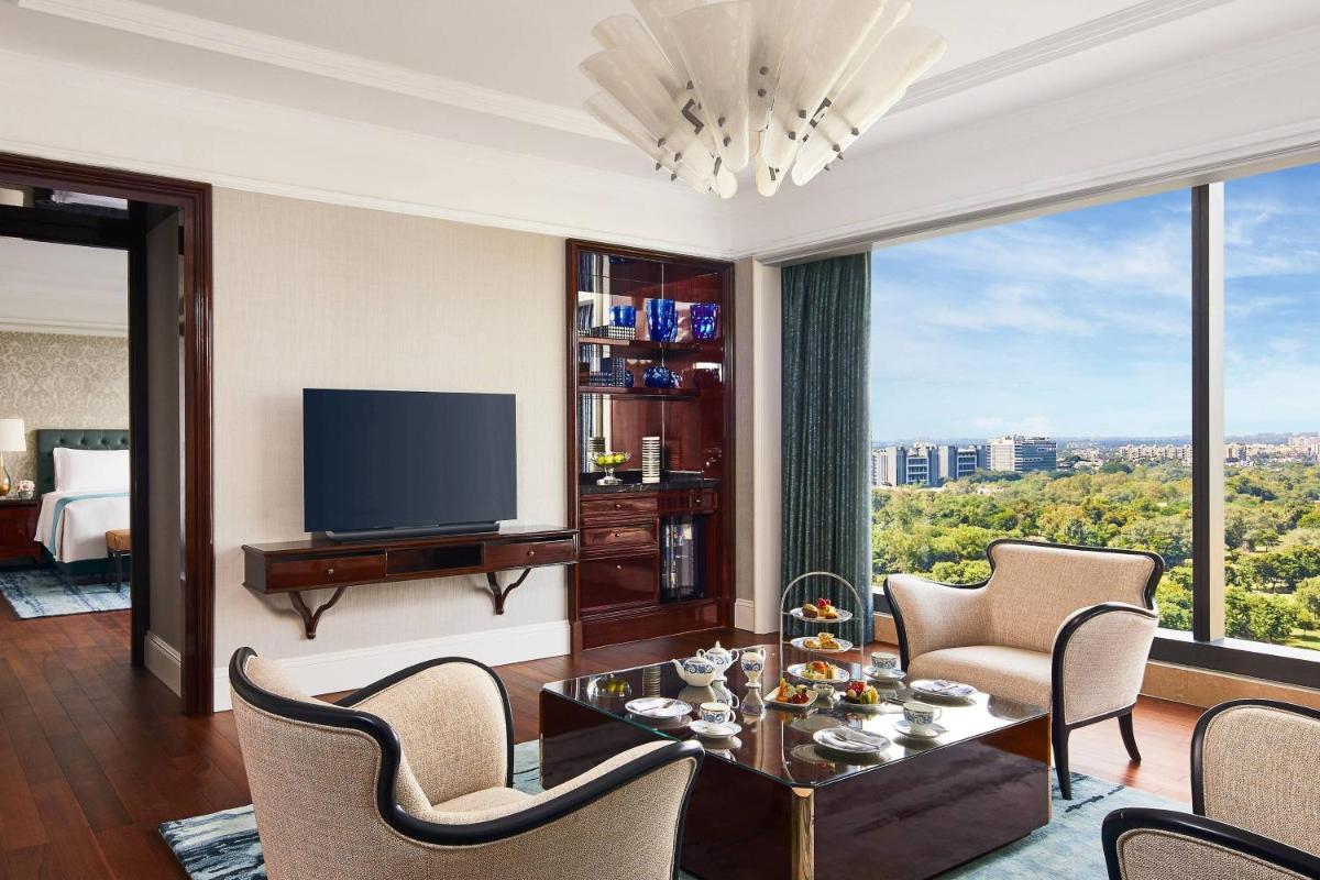 a living room with a television and a table and chairs at The Ritz-Carlton, Pune in Pune