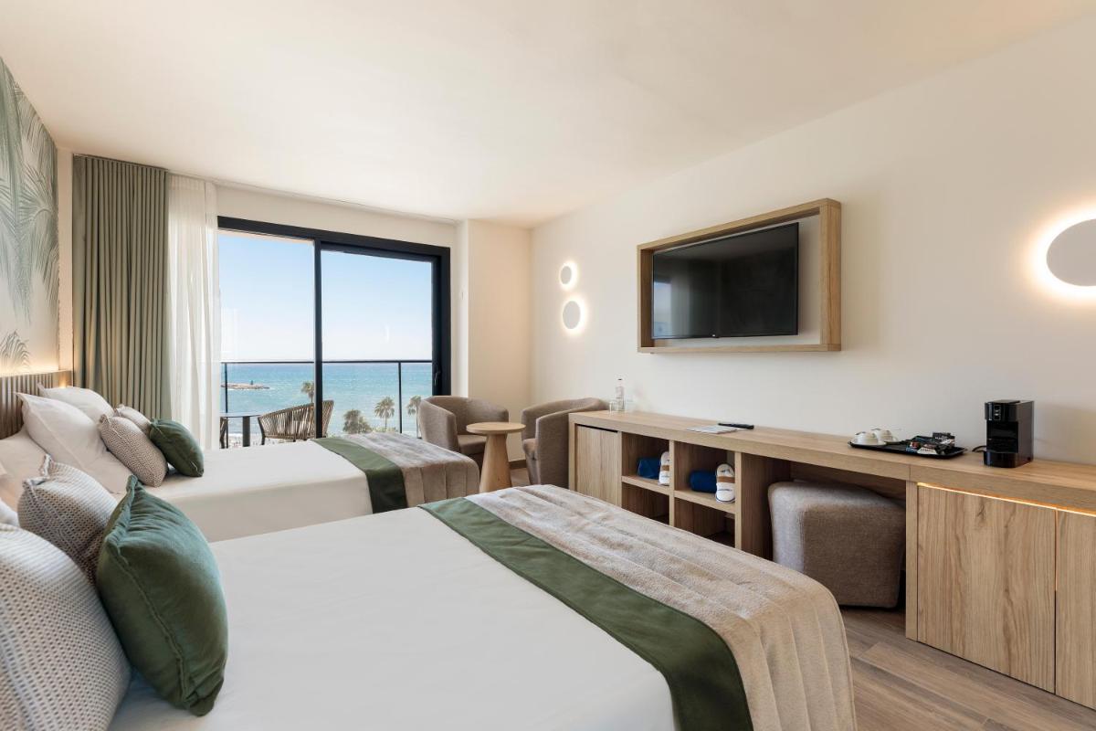 Una habitación de hotel con dos camas y un televisor de pantalla plana. en Hotel Best Triton, en Benalmádena