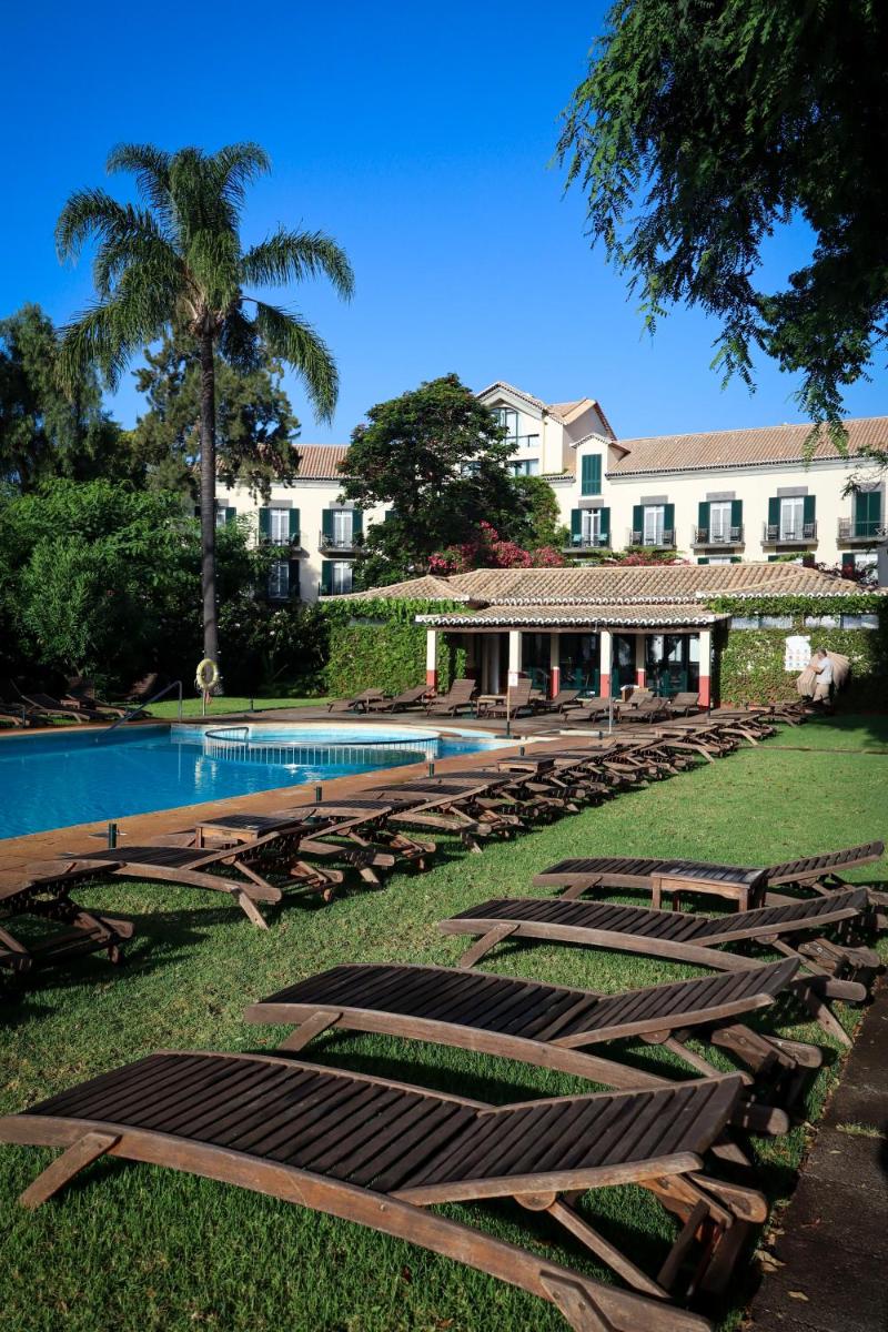 um grupo de espreguiçadeiras e uma piscina em Quinta da Bela Vista no Funchal