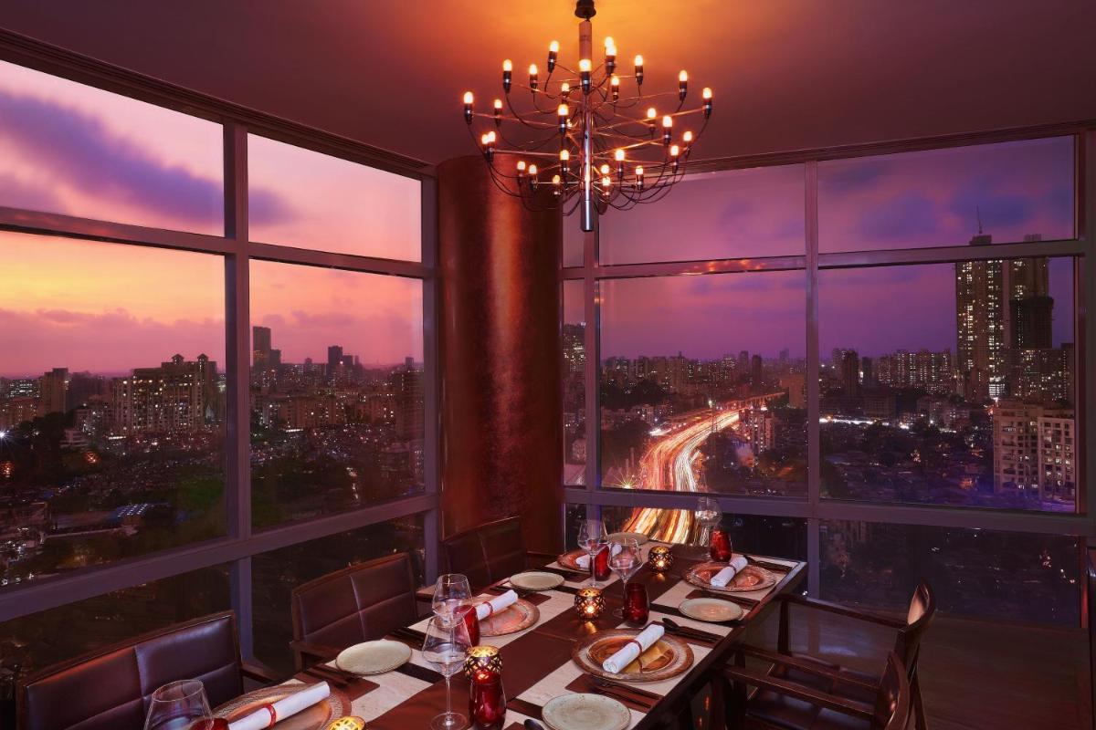 a dining room with a view of a city at The Westin Mumbai Garden City in Mumbai