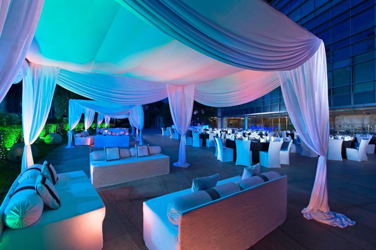 a marquee with blue and pink curtains and tables and chairs at The Westin Mumbai Garden City in Mumbai +53 photos