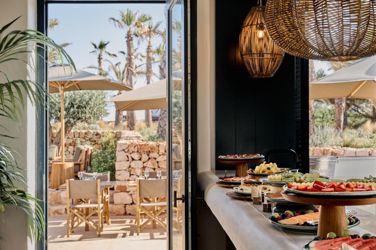 una mesa buffet con comida en un restaurante en CAP Menorca Relais & Chateaux, en Son Bou