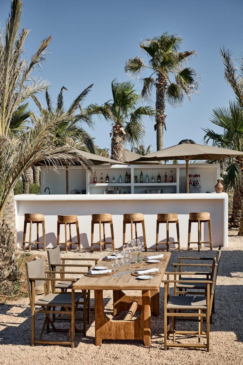una mesa y sillas frente a un restaurante en CAP Menorca Relais & Chateaux, en Son Bou