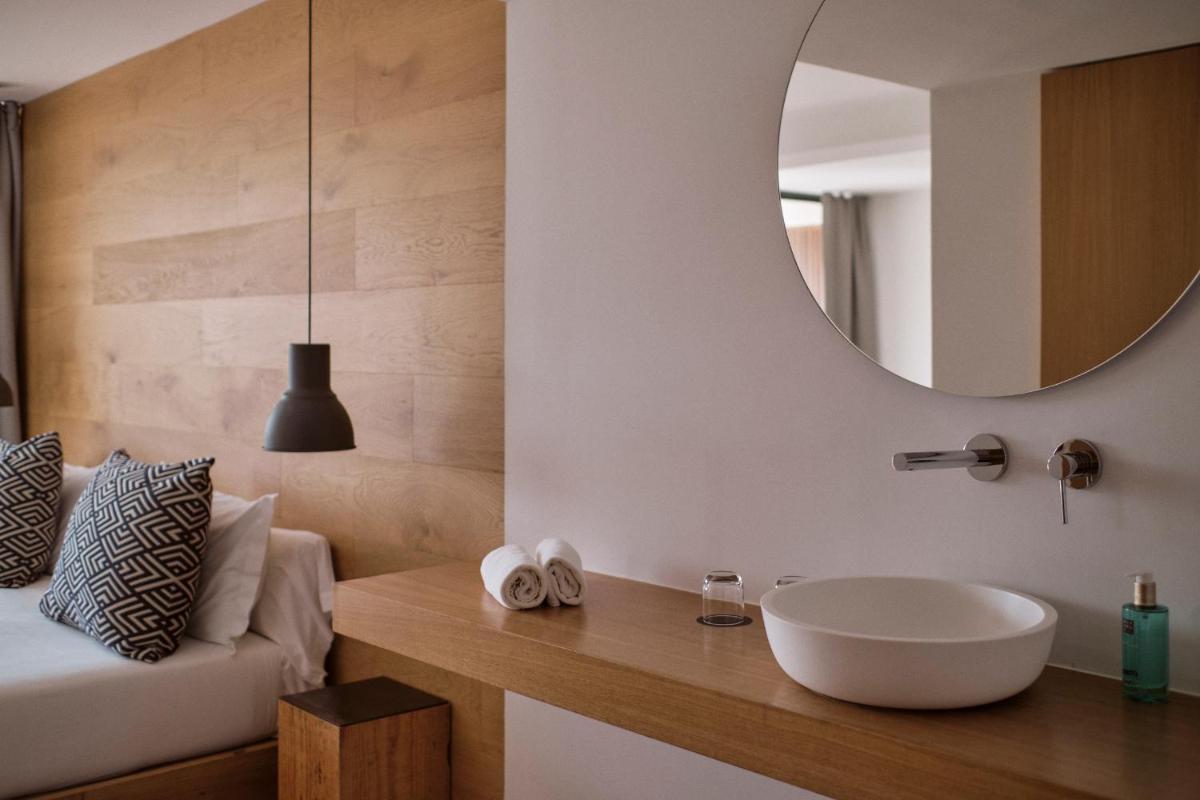un baño con lavabo y espejo en Las Gaviotas Suites Hotel & Spa, en Playa de Muro
