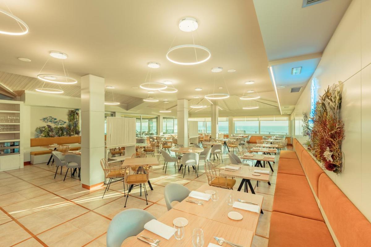 un restaurante con mesas y sillas en una cafetería en Talaso Atlántico, en Mougás