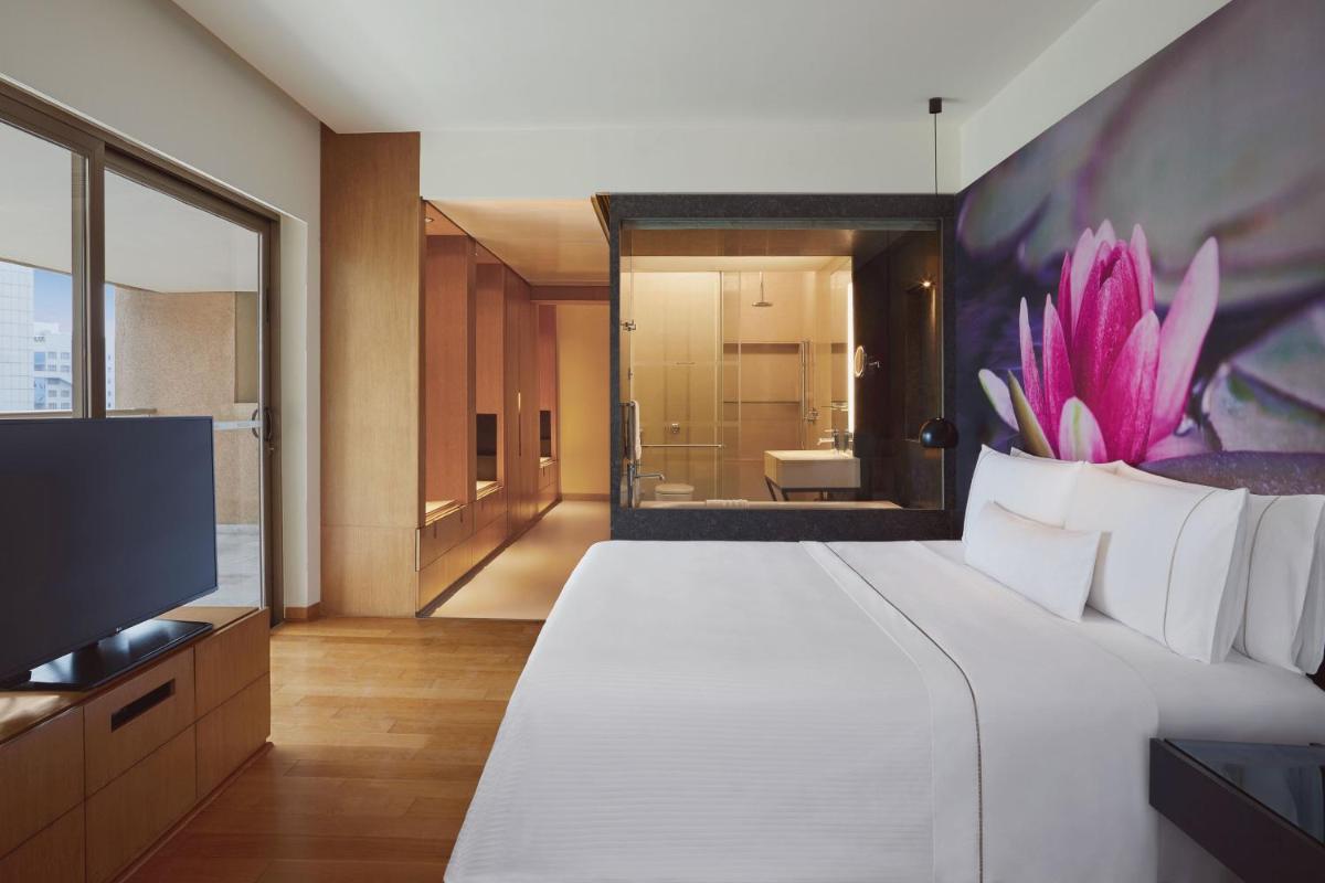a bedroom with a large white bed and a television at The Westin Hyderabad Mindspace in Hyderabad
