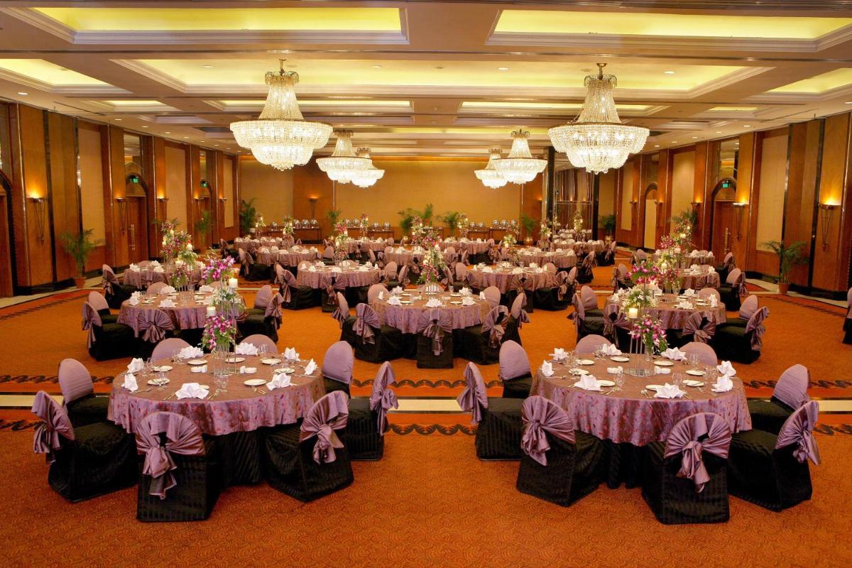 a large banquet hall with tables with purple tablecloths at Eros Hotel New Delhi, Nehru Place in New Delhi a large banquet hall with tables with purple tablecloths at Eros Hotel New Delhi, Nehru Place in New Delhi