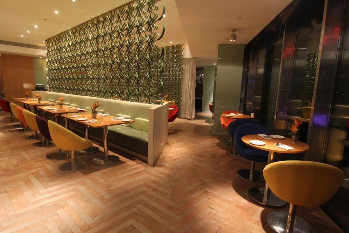 a dining room with tables and chairs and wine glasses at The Park Hyderabad, Banjara Hills near Hussain Sagar Lake in Hyderabad a dining room with tables and chairs and wine glasses at The Park Hyderabad, Banjara Hills near Hussain Sagar Lake in Hyderabad