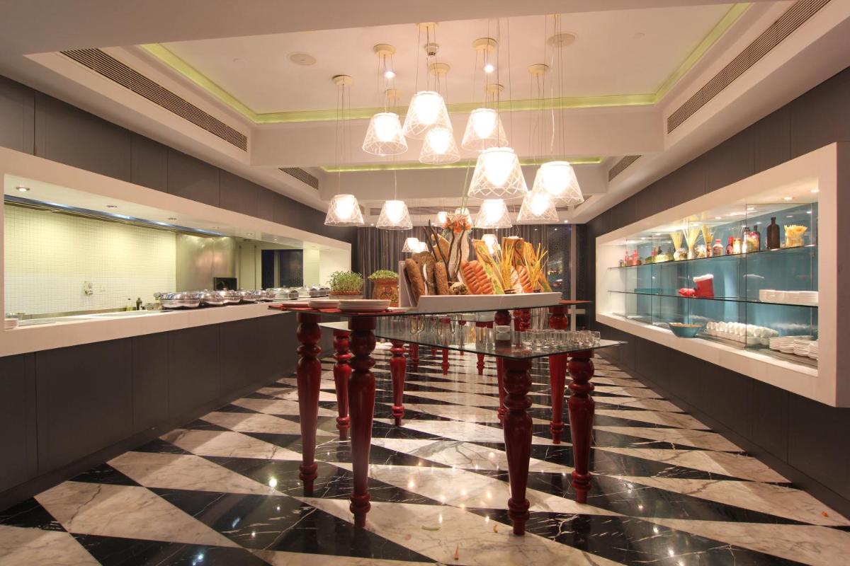 a restaurant with a counter with a table with food at The Park Hyderabad, Banjara Hills near Hussain Sagar Lake in Hyderabad a restaurant with a counter with a table with food at The Park Hyderabad, Banjara Hills near Hussain Sagar Lake in Hyderabad