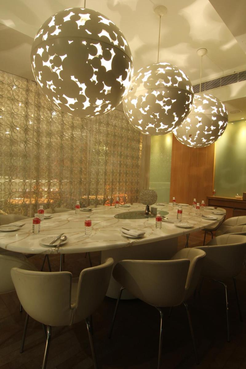 a large table in a room with chairs and lights at The Park Hyderabad, Banjara Hills near Hussain Sagar Lake in Hyderabad a large table in a room with chairs and lights at The Park Hyderabad, Banjara Hills near Hussain Sagar Lake in Hyderabad