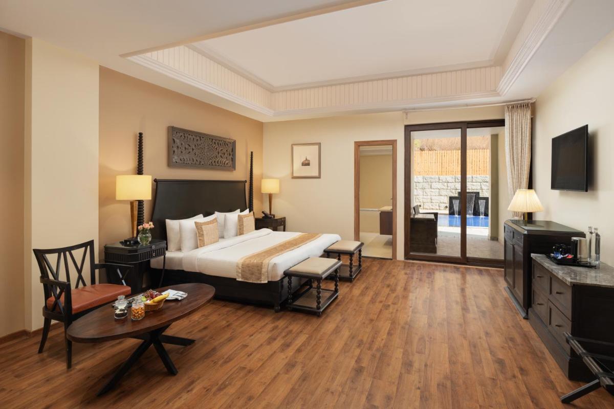 a hotel room with a bed and a table at Essentia Luxury Resort & Spa Udaipur in Udaipur
