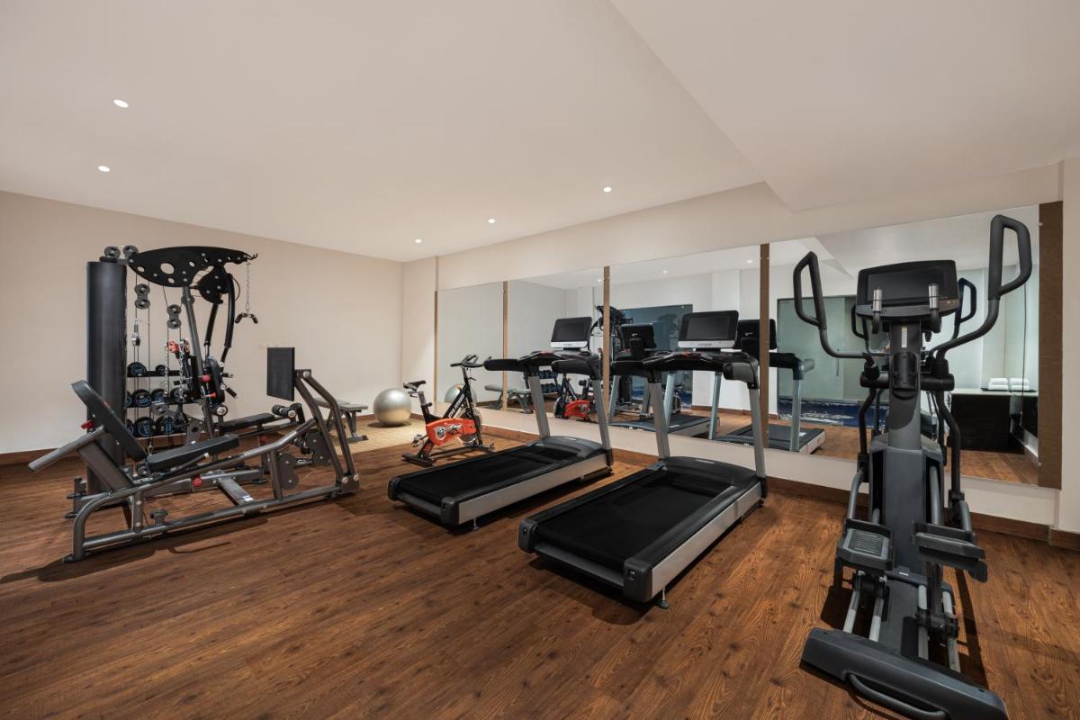 a gym with several treadmills and exercise machines at Essentia Luxury Resort & Spa Udaipur in Udaipur