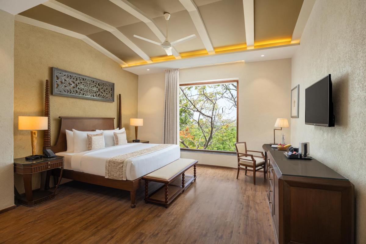 a hotel room with a bed and a window at Essentia Luxury Resort & Spa Udaipur in Udaipur