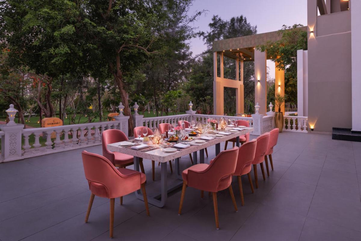 a long table and chairs on a patio at Essentia Luxury Resort & Spa Udaipur in Udaipur