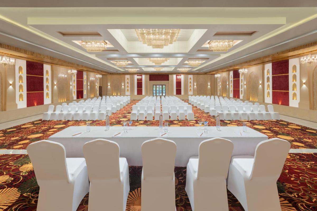 a large banquet hall with white tables and chairs at Essentia Luxury Resort & Spa Udaipur in Udaipur