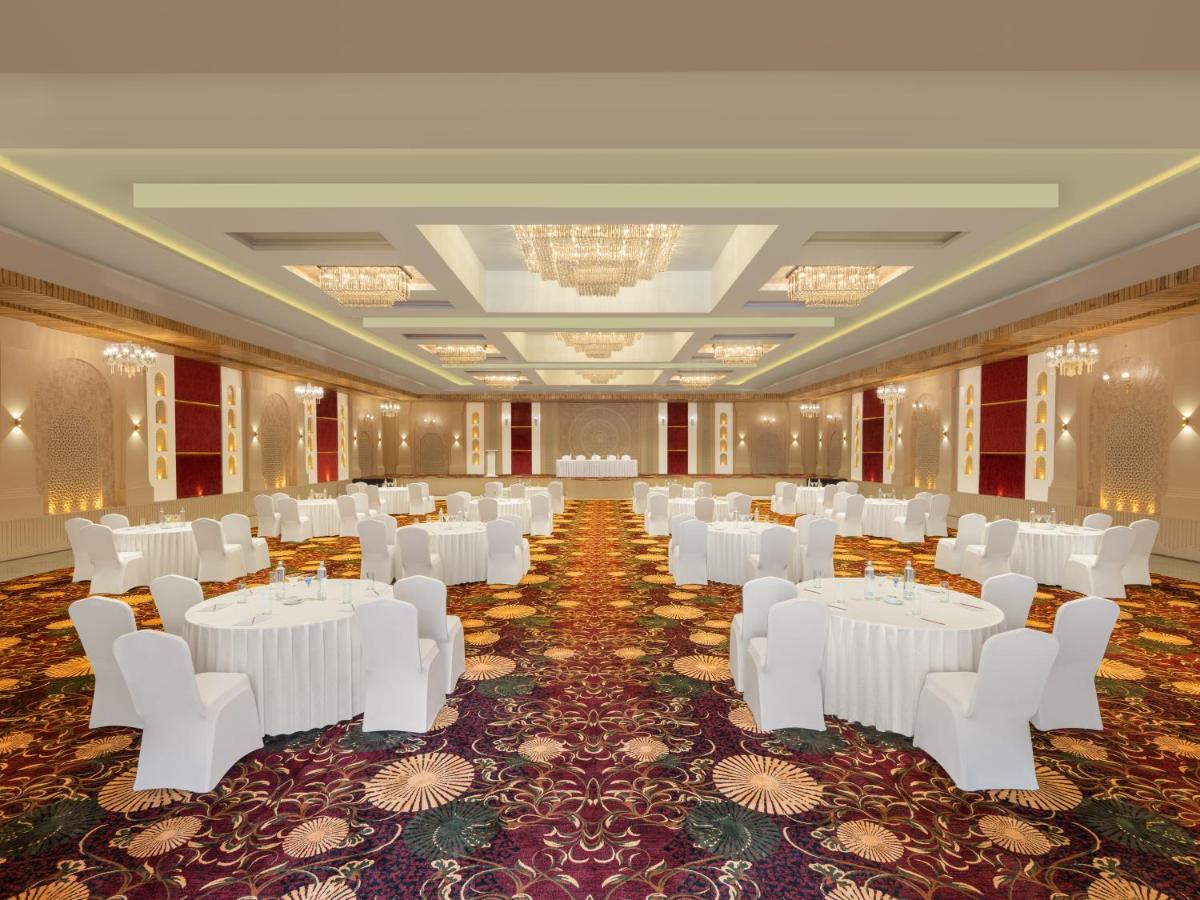 a banquet hall with white tables and white chairs at Essentia Luxury Resort & Spa Udaipur in Udaipur