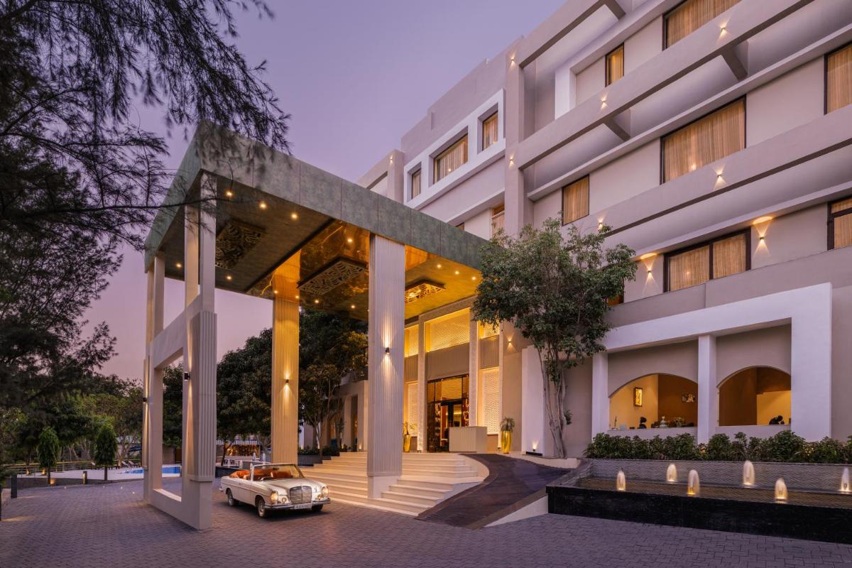an old car parked in front of a building at Essentia Luxury Resort & Spa Udaipur in Udaipur