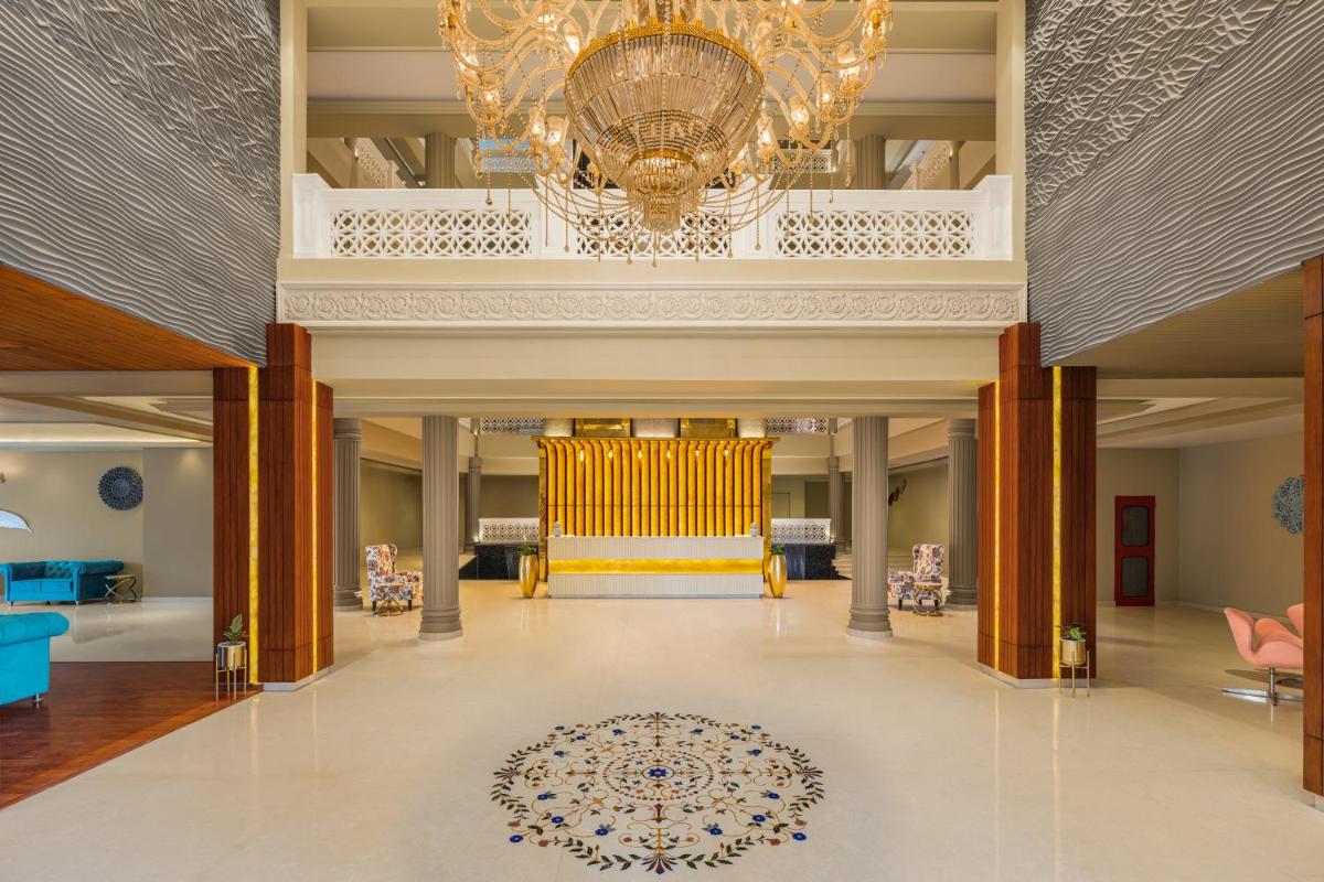 a large lobby with a chandelier and a chair at Essentia Luxury Resort & Spa Udaipur in Udaipur