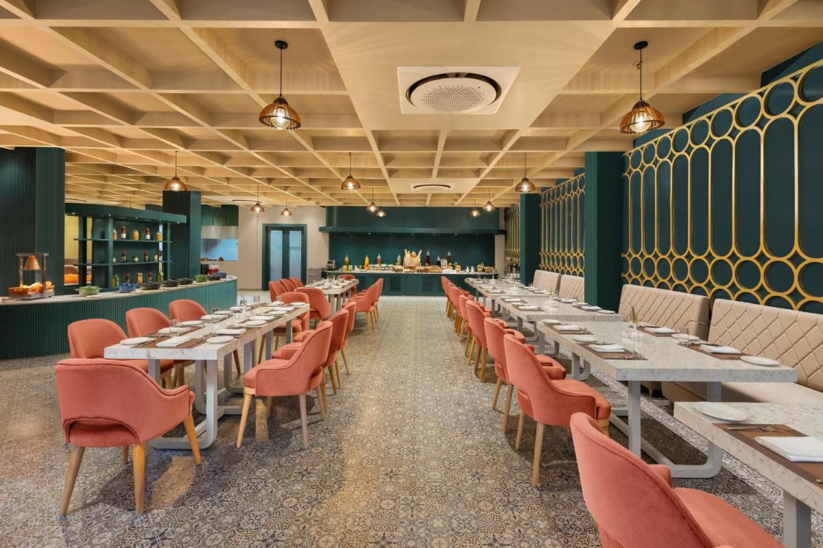 a dining room with tables and chairs and a bar at Essentia Luxury Resort & Spa Udaipur in Udaipur