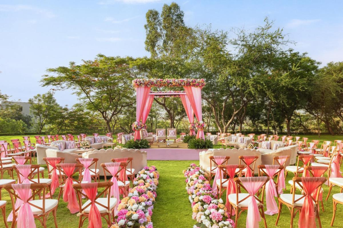 a set up for a wedding with pink chairs and an arch at Essentia Luxury Resort & Spa Udaipur in Udaipur