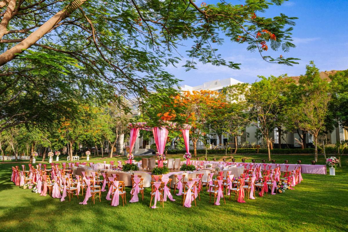 a row of tables and chairs in a park at Essentia Luxury Resort & Spa Udaipur in Udaipur