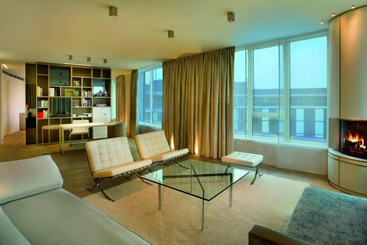 ein Wohnzimmer mit Couch und Kamin in der Unterkunft The Ritz-Carlton, Wolfsburg in Wolfsburg + 37 Fotos