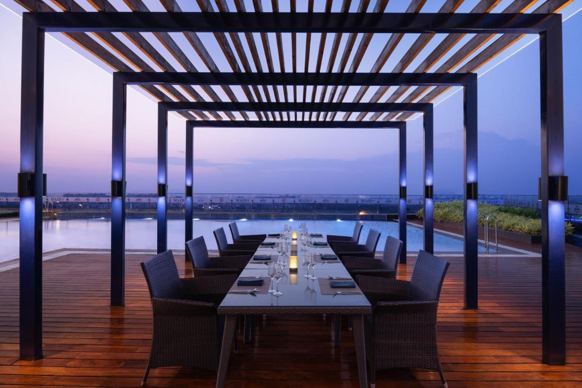 a long dining room with a long table and chairs at Marriott Executive Apartments Hyderabad in Hyderabad