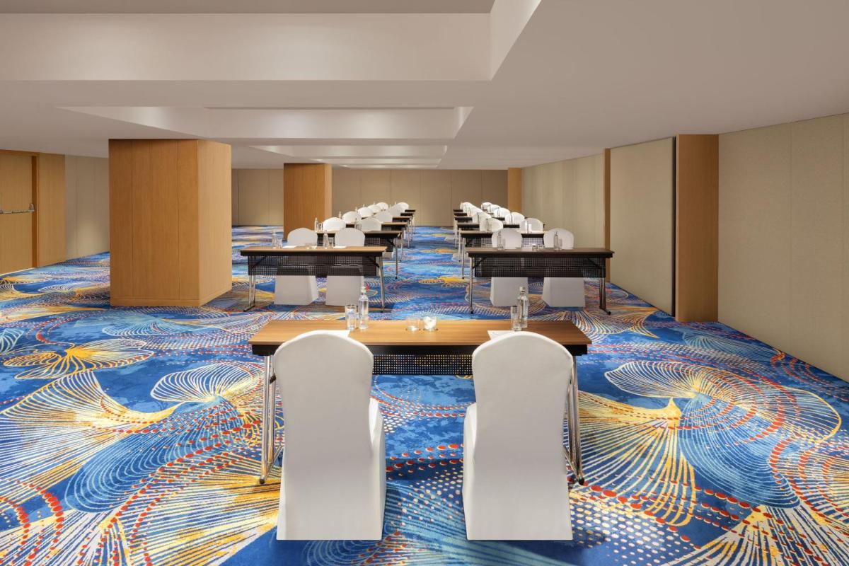 a conference room with tables and chairs on a colorful carpet at Marriott Executive Apartments Hyderabad in Hyderabad +37 photos