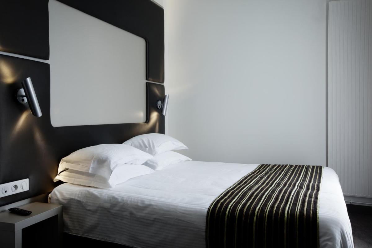 Un ou plusieurs lits dans un hébergement de l'établissement Brit Hotel de Grignan Vichy