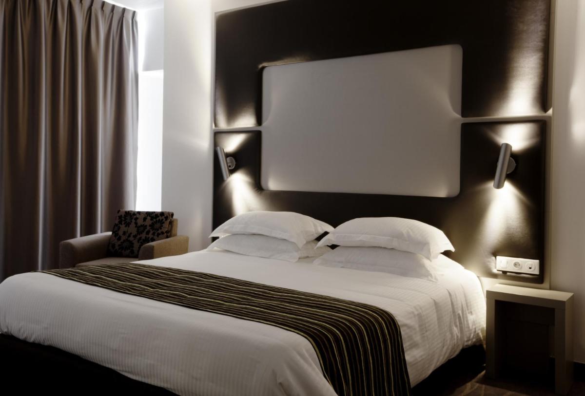 Un ou plusieurs lits dans un hébergement de l'établissement Brit Hotel de Grignan Vichy