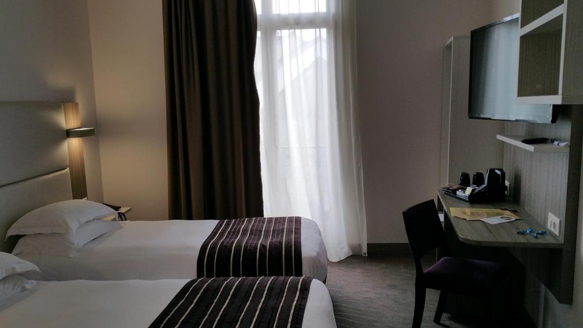 Un ou plusieurs lits dans un hébergement de l'établissement Brit Hotel de Grignan Vichy