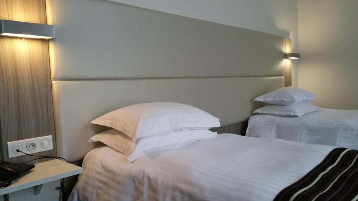 Un ou plusieurs lits dans un hébergement de l'établissement Brit Hotel de Grignan Vichy